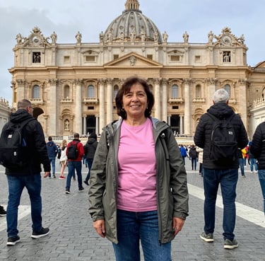 Smiling middle-aged woman enjoying a scenic Italian landscape during her trip.