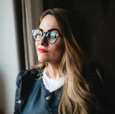 Frau um die 45 steht  entspannt am Fenster