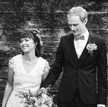 a bride and groom holding hands and smiling