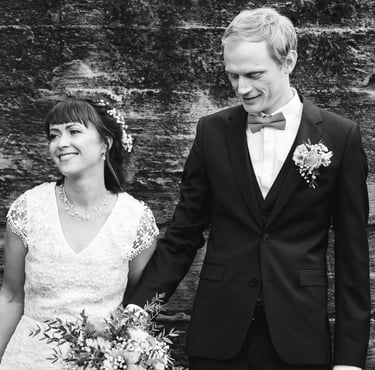 a bride and groom holding hands and smiling