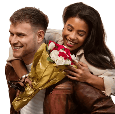 a man and woman smiling and holding flowers