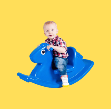 a baby boy sitting on a rocking horse