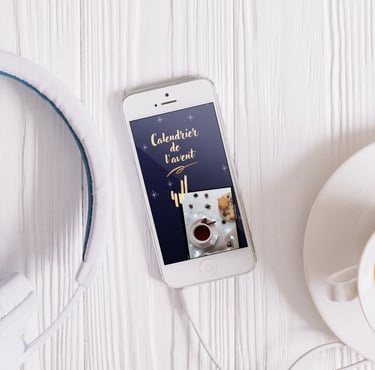 Un téléphone portable est posé sur une table blanche, on y voit un calendrier de l'avent virtuel