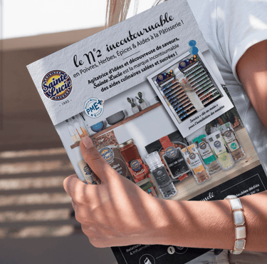 Un magazine tenue en main par une femme, on peut y voir une parution publicitaire.