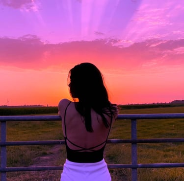 woman watching sunset with soft aesthetic sky, personal style inspiration and curated fashion lifest