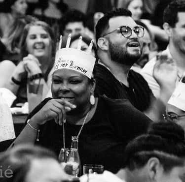black woman in show audience with birthday crown smiling