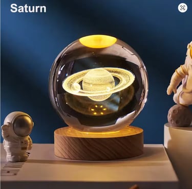 Glowing 3D crystal ball night light featuring Saturn and its rings on a wooden base.