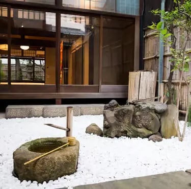 Peaceful Japanese zen garden with stone basin bamboo fence and traditional wooden house