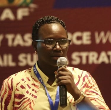 a woman in a yellow shirt and glasses speaking into a microphone