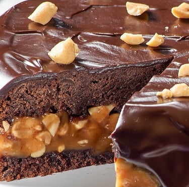 كعكة مغطاة بكريمة الشوكولاتة والمكسرات في الأعلى