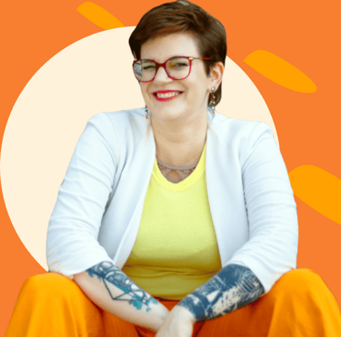 ein Photo von Swana Schuchmann mit orangenem Hintergrund. Sie lächelt.