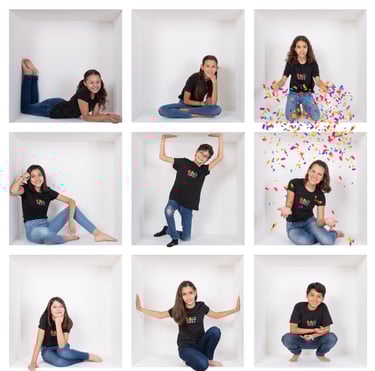a woman in a black shirt and jeans sitting on a white wall