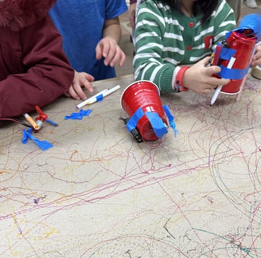 a young child is testing their STEMVillage drawing bot