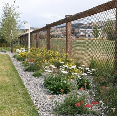 a fenced in area with a fence and flowers