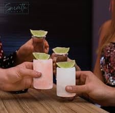 Salt shot glasses with lime held in a toast
