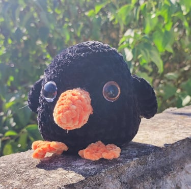 a stuffed penguin sitting on a ledge