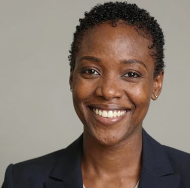 A smiling woman with curly hair enjoying a sunny outdoor cafe.