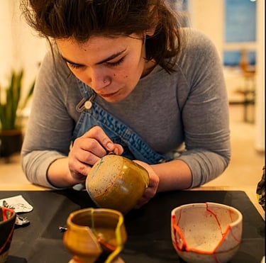 a woman is repairing ceramics with kintsugi reparatur 