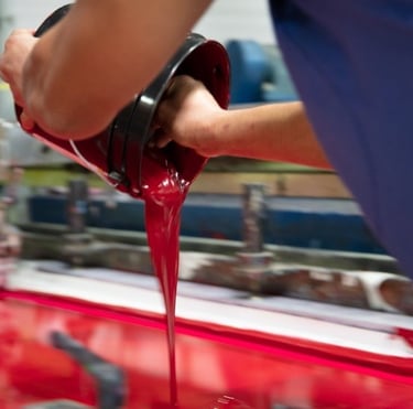 a person is pouring liquid into a red liquid