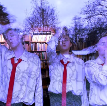 Film still from "Because We Cannot Do Otherwise" by Tina Bikic of three performers in red ties reflected in a large window.