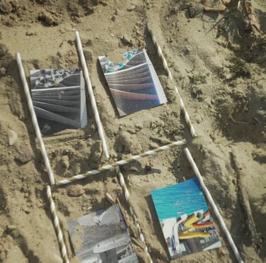 Film still from Excitement by Tina Bikic showing photographs arranged in sand and framed a storyboard with stripped sticks.