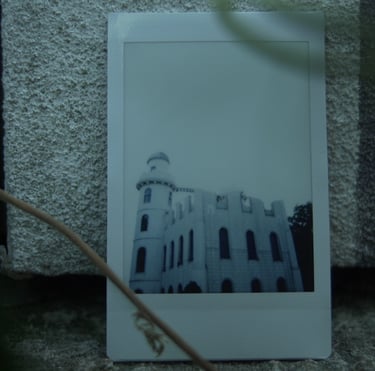 Photograph of a white castle placed against a stone wall, still from Nostalgia by Tina Bikic.