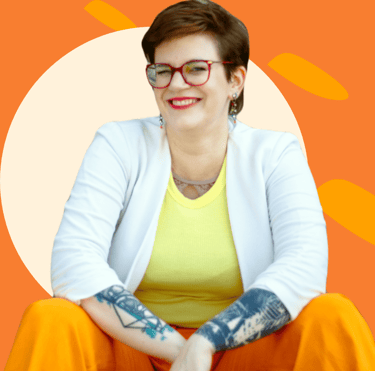 ein Photo von Swana Schuchmann mit orangenem Hintergrund. Sie lächelt.