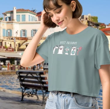 Woman wearing a Best Friends graphic crop top t-shirt by a sunny European harbor.