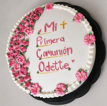 pastel con flores rosas y la leyenda "Mi primera comunión"