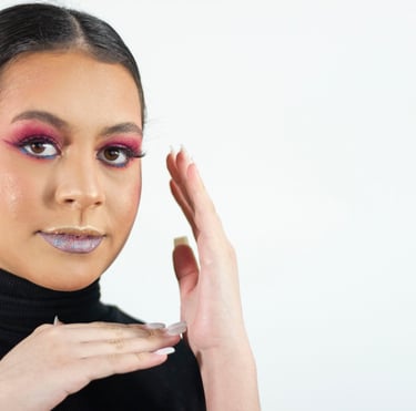 Mujer joven que usa una sombra de ojos rosa intensa y un lápiz labial plateado brillante para lograr