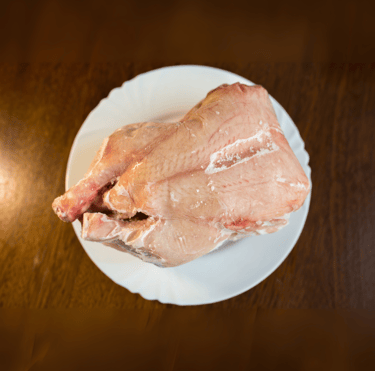 a raw chicken breasty on a plate