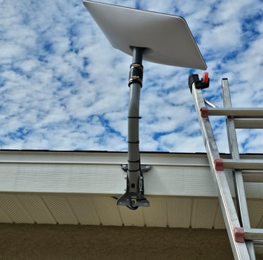 Starlink satellite dish mounted on a home rooftop with a clear blue sky background.
