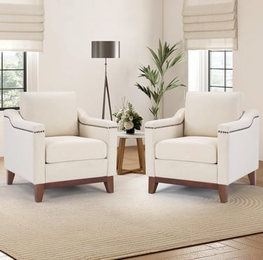 Pair of cream upholstered accent chairs with nailhead trim in a modern living room setting.