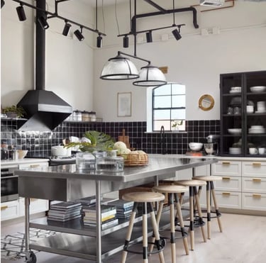 Modern residential kitchen featuring a mobile island with stainless steel benchtops and wooden bar stools.