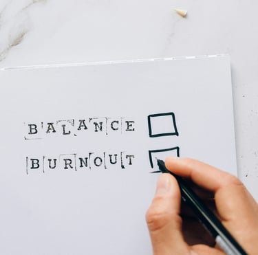 a person holding a pen ticking the box for balance versus burnout