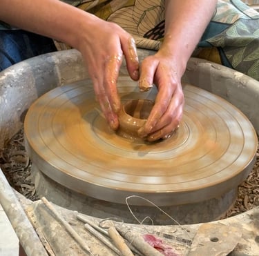 Photo de mains d'une artisane en train de travailler une céramique