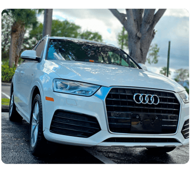 Front view of a white Audi Q3 luxury compact SUV parked outdoors on a paved surface.