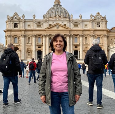 Smiling middle-aged woman enjoying a scenic Italian landscape during her trip.