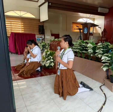 Elementary Student kneeling and praying with a mic
