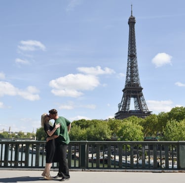 Deux amoureux s'embrassent decant la Tour Eiffel sur le pont Bir Hakeim à Paris