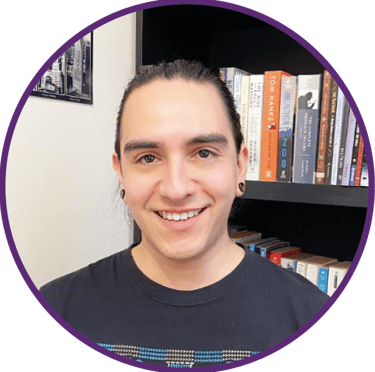 a man with a smile on his face and a bookcase in front of a