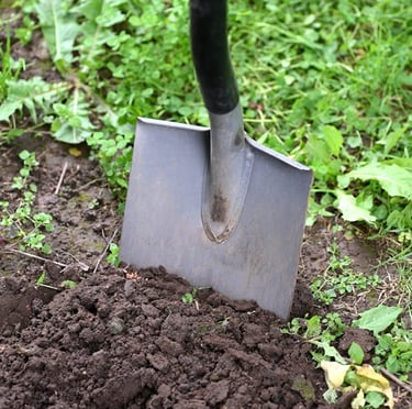 a person digging up soil with a showel