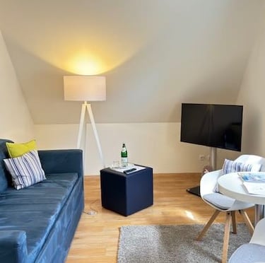 Hotel DunenNest - Kleine Suite, Wohnzimmer, Sofa, Sitzecke mit Tisch