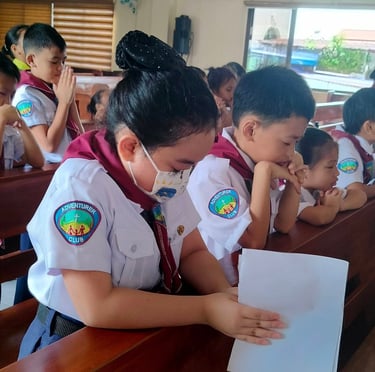Elementary scout students praying