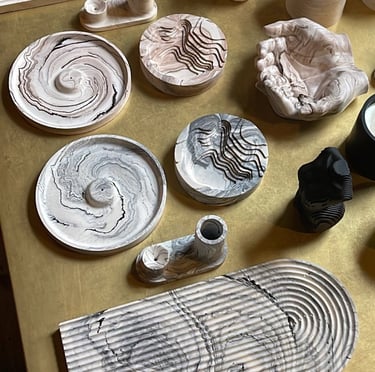 a table with a lot of different types of jesmonite pieces and candles