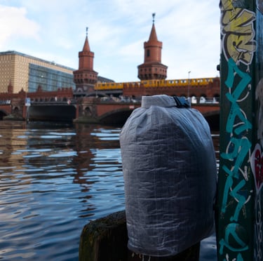A dyneema dry bag and a train crossing a bridge in the background