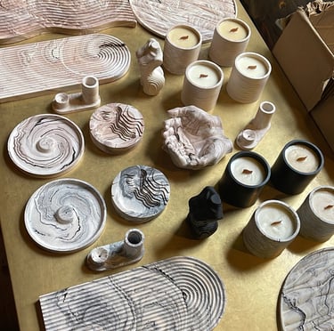 a table with a lot of different types of jesmonite pieces and candles