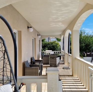 The photo shows the balcony of the apartment with a dining set. 