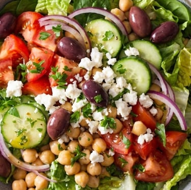 Fresh Greek salad bowl with chickpeas, feta cheese, kalamata olives, and cucumbers.