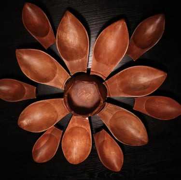 Rustic antique curved wooden stool on a light timber floor with linen curtains in the background.
